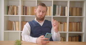 Nahaufnahmeporträt des jungen kaukasischen Geschäftsmannes, der das Telefon verwendet und Kopfschmerzen zuhause ermüdet sind im B stock video Nahaufnahmeporträt des jungen kaukasischen Geschäftsmannes, der das Telefon verwendet und Kopfschmerzen zuhause ermüdet sind im B stock video