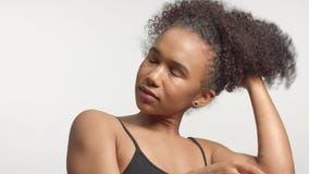 Nahaufnahmeporträt s des jungen Mischrassemodells mit dem gelockten Haar im Studio mit natürlichem neutralem Make-up stock video footage Nahaufnahmeporträt s des jungen Mischrassemodells mit dem gelockten Haar im Studio mit natürlichem neutralem Make-up stock video footage