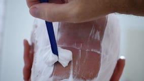 Nahes hohes Bild mit einem Mann, der seinen Kahlkopf rasiert stock video footage Nahes hohes Bild mit einem Mann, der seinen Kahlkopf rasiert stock video footage