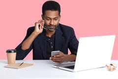 Nahes hohes Porträt des Afroamerikanergeschäftsmannes überprüfte E-Mail an seinem intelligenten Telefon, sitzt vor dem Laptop und stockfotos Nahes hohes Porträt des Afroamerikanergeschäftsmannes überprüfte E-Mail an seinem intelligenten Telefon, sitzt vor dem Laptop und stockfotos
