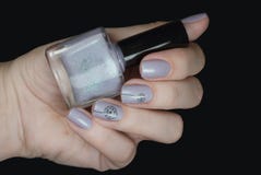 Nail polish in a hand on a black background. Gentle nail art with dandelions. Stock Photography Nail polish in a hand on a black background. Gentle nail art with dandelions. Stock Photography
