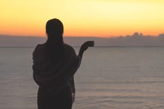 Naked beautiful female with wet hair wrapped in a blanket with cup of coffee standing on the glass balcony early morning at sunris stock photos Naked beautiful female with wet hair wrapped in a blanket with cup of coffee standing on the glass balcony early morning at sunris stock photos