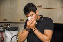 Nariz que sopla del hombre joven en tejido foto de archivo libre de regalías Nariz que sopla del hombre joven en tejido foto de archivo libre de regalías