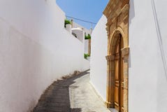 Narrow street in Lindos town on Rhodes island, Dodecanese, Greece. Beautiful scenic old ancient white houses with flowers. Famous stock photos Narrow street in Lindos town on Rhodes island, Dodecanese, Greece. Beautiful scenic old ancient white houses with flowers. Famous stock photos