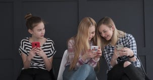 Nastoletnie dziewczyny ma zabawę podczas gdy wysylanie sms na telefonach komórkowych zdjęcie wideo Nastoletnie dziewczyny ma zabawę podczas gdy wysylanie sms na telefonach komórkowych zdjęcie wideo