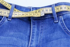 Nastro di centimetro come cinghia in jeans primo piano, concetto di peso di perdita Stile di vita sano fotografia stock libera da diritti Nastro di centimetro come cinghia in jeans primo piano, concetto di peso di perdita Stile di vita sano fotografia stock libera da diritti