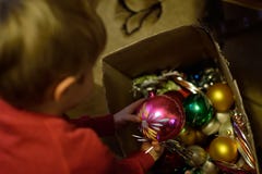 Natale in una casa difficile Il bambino decora l'albero di Natale fotografia stock libera da diritti Natale in una casa difficile Il bambino decora l'albero di Natale fotografia stock libera da diritti