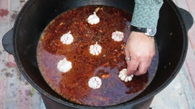 National Uzbek dish pilaf, pilaw, plov, rice with meat in big pan. Cooking process in a cauldron on fire. Add a red
