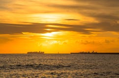 Navire porte-conteneurs sur l'horizon au coucher du soleil photographie stock Navire porte-conteneurs sur l'horizon au coucher du soleil photographie stock