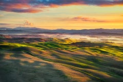 Nebeliges Panorama Volterra, Rolling Hills und Grünfelder auf sunse lizenzfreies stockbild Nebeliges Panorama Volterra, Rolling Hills und Grünfelder auf sunse lizenzfreies stockbild
