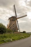 Nederlandse windmolen met enorme molenbladen rond de hoek van de weg royalty-vrije stock foto's Nederlandse windmolen met enorme molenbladen rond de hoek van de weg royalty-vrije stock foto's