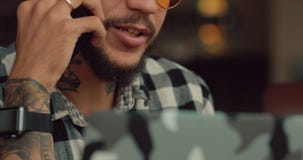 Negociaciones del hombre por el smartphone que se sienta en el café, comunicación empresarial Negociaciones del hombre por el smartphone que se sienta en el café, comunicación empresarial