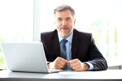 Negócio, povos e conceito da tecnologia - homem de negócios de sorriso feliz com escritório do laptop foto de stock royalty free Negócio, povos e conceito da tecnologia - homem de negócios de sorriso feliz com escritório do laptop foto de stock royalty free