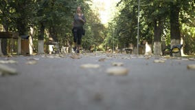Nehmen Sie das junge Mädchen ab, das auf Musik und Betrieb im Park an einem schönen sonnigen Herbsttag hört - stock video Nehmen Sie das junge Mädchen ab, das auf Musik und Betrieb im Park an einem schönen sonnigen Herbsttag hört - stock video