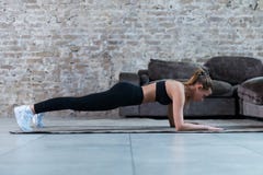 Nehmen Sie den jungen Brunette ab, der die schwarze Turnhallenkleidung trägt, die Abdominal- Brücke oder vordere Plankenübung in lizenzfreie stockbilder Nehmen Sie den jungen Brunette ab, der die schwarze Turnhallenkleidung trägt, die Abdominal- Brücke oder vordere Plankenübung in lizenzfreie stockbilder