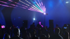 Neon lights shining over dancing crowd