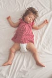 Neonata che dorme sulla parte posteriore con a braccia aperte e senza tettarella in un letto con gli strati bianchi Sonno pacific fotografia stock Neonata che dorme sulla parte posteriore con a braccia aperte e senza tettarella in un letto con gli strati bianchi Sonno pacific fotografia stock