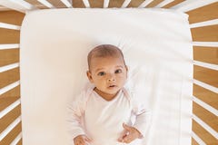 Neonata sveglia che si trova nella greppia immagine stock Neonata sveglia che si trova nella greppia immagine stock