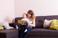 Neonato che ascolta la sua lettura della madre fotografie stock Neonato che ascolta la sua lettura della madre fotografie stock