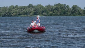 Nette Familie, die auf ein Boot am sonnigen Tag schwimmt stock video Nette Familie, die auf ein Boot am sonnigen Tag schwimmt stock video