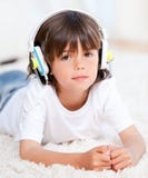 Nette hörende Musik des kleinen Jungen, die auf Fußboden liegt stockfoto Nette hörende Musik des kleinen Jungen, die auf Fußboden liegt stockfoto