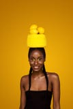 Nette junge afrikanische Frau mit gelbem Make-up auf ihren Augen Weibliches Modell gegen gelben Hintergrund mit gelben Zitronen lizenzfreie stockbilder Nette junge afrikanische Frau mit gelbem Make-up auf ihren Augen Weibliches Modell gegen gelben Hintergrund mit gelben Zitronen lizenzfreie stockbilder