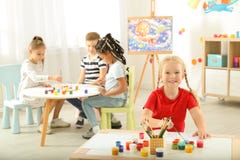 Nette kleine Kindermalerei an der Lektion lizenzfreie stockbilder Nette kleine Kindermalerei an der Lektion lizenzfreie stockbilder