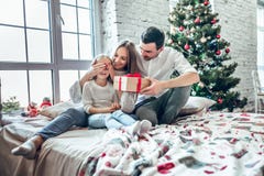 Nette Mutter, Vater und ihr nettes Tochtermädchen, die Geschenke austauschen Elternteil und wenig Kind, die Spaß nahe Weihnachtsb lizenzfreie stockfotos Nette Mutter, Vater und ihr nettes Tochtermädchen, die Geschenke austauschen Elternteil und wenig Kind, die Spaß nahe Weihnachtsb lizenzfreie stockfotos