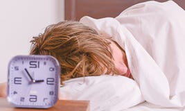 Netter junger Mann wacht auf, nachdem er morgens geschlafen hat Mann, der in Bett ausdehnt Entspannen Sie sich im Bett stockbilder Netter junger Mann wacht auf, nachdem er morgens geschlafen hat Mann, der in Bett ausdehnt Entspannen Sie sich im Bett stockbilder