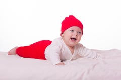 Nettes glückliches Babymädchenkind, das im Bett liegt Stockfotos Nettes glückliches Babymädchenkind, das im Bett liegt Stockfotos