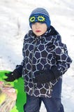 Nettes Kinderrodeln Kleinkindjunge, der einen Schlitten im Schnee reitet lizenzfreies stockfoto Nettes Kinderrodeln Kleinkindjunge, der einen Schlitten im Schnee reitet lizenzfreies stockfoto