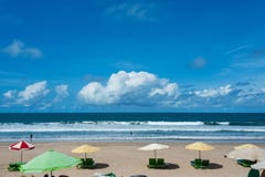 Nettoyez la plage tropicale vide avec des lits pliants sous le parapluie et une belle vue de l'océan calme sous le ciel bleu Photo libre de droits Nettoyez la plage tropicale vide avec des lits pliants sous le parapluie et une belle vue de l'océan calme sous le ciel bleu Photo libre de droits