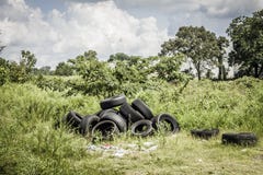 Neumáticos usados dejados en un campo imagen de archivo Neumáticos usados dejados en un campo imagen de archivo