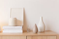 Neutral colored vases, photo frame and stack of books on bureau shelf stock photo Neutral colored vases, photo frame and stack of books on bureau shelf stock photo