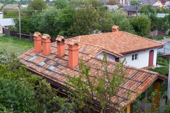 New brick house with red roof tile pattern and modular chimney, plastic windows and rain gutter stock photography New brick house with red roof tile pattern and modular chimney, plastic windows and rain gutter stock photography