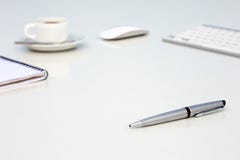 New Day at Office Concept White Table with Computer Blank Notepad and Cup of Coffee Side View stock photo New Day at Office Concept White Table with Computer Blank Notepad and Cup of Coffee Side View stock photo