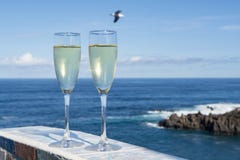 New year celebration with two glasses of champagne or Spanish cava sparkling wine and view on blue Atlantic ocean, Canary islands