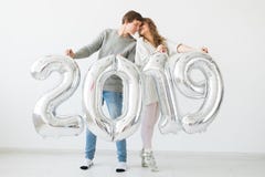 New 2019 Year is coming concept - Cheerful young man and woman are holding silver colored numbers royalty free stock photo New 2019 Year is coming concept - Cheerful young man and woman are holding silver colored numbers royalty free stock photo