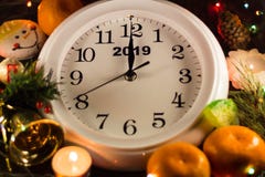 New Year's clock. Around tangerines, candles and Christmas tree. Happy New Year. Chimes beat 12 royalty free stock photo New Year's clock. Around tangerines, candles and Christmas tree. Happy New Year. Chimes beat 12 royalty free stock photo