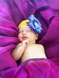 Newborn baby girl smiling sleeping on bed ultra violet purple