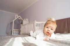 A newborn baby is lying on his stomach in the nursery on the bed. royalty free stock photography A newborn baby is lying on his stomach in the nursery on the bed. royalty free stock photography