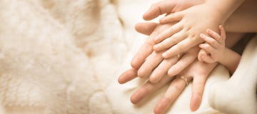 Newborn Child Hand. Closeup Of Baby Hand Into Parents Hands. Family, Maternity And Birth Concept. Banner Royalty Free Stock Image