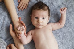 Newborn Naked pretty baby boy lying and looking on grey sheet, top view royalty free stock image Newborn Naked pretty baby boy lying and looking on grey sheet, top view royalty free stock image