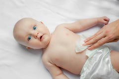 Newborn младенец получая изменение пеленки: мама обтирая дно младенца с младенцем обтирает на белой предпосылке очищать концепции стоковые изображения Newborn младенец получая изменение пеленки: мама обтирая дно младенца с младенцем обтирает на белой предпосылке очищать концепции стоковые изображения