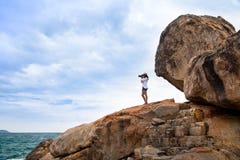 Beautiful woman taking a photo a mountain over a sea at Nha Trang, Vietnam. stock photo Beautiful woman taking a photo a mountain over a sea at Nha Trang, Vietnam. stock photo