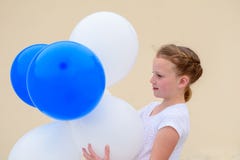 Ni?a feliz con los globos azules y blancos imagen de archivo Ni?a feliz con los globos azules y blancos imagen de archivo