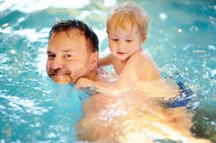 Ni?o peque?o feliz con su padre en piscina fotos de archivo Ni?o peque?o feliz con su padre en piscina fotos de archivo