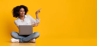 Happy Woman With Laptop Pointing At Copy Space Over Yellow Background