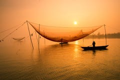 Nicht identifizierter Fischer überprüft seine Netze am frühen Morgen auf Fluss in Hoian, Vietnam stockbilder Nicht identifizierter Fischer überprüft seine Netze am frühen Morgen auf Fluss in Hoian, Vietnam stockbilder