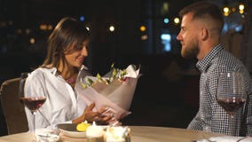 Niespodzianki Piękna romantyczna para w kawiarni Młody człowiek przedstawia kwiaty jego ukochany Odczucie szczęście zbiory wideo Niespodzianki Piękna romantyczna para w kawiarni Młody człowiek przedstawia kwiaty jego ukochany Odczucie szczęście zbiory wideo